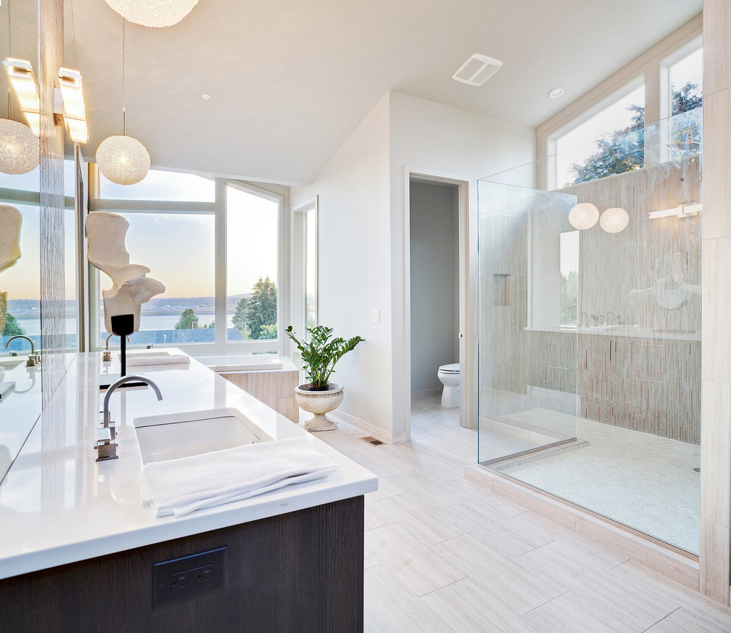 Light-filled bathroom renovation with a glass shower and freestanding tub