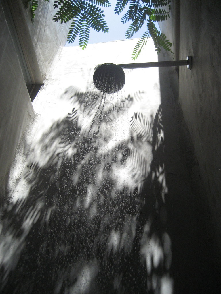 Outdoor shower head under natural light through leaves